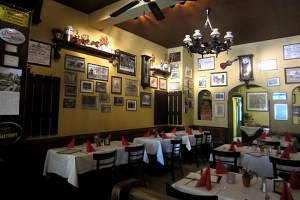 An den Wänden hängen zahlreiche Fotos und Zeitungsausschnitte.